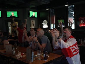 With an English flag around his shoulders, soccer fan Scott Chambers celebrates during an English national team victory over Sweden in the FIFA World Cup on July 7.