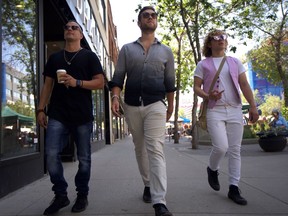 (left to right) Tallus Scott, Jordan Welbourne, and Myk Ulan-Hohol of the new band W3APONS walk down Second Avenue during the sidewalk sale in Saskatoon on July 6.