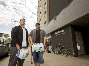 Ryan McHugh, right, and his son Brendon McHugh, stand for a photo after distributing water at the Lighthouse in Saskatoon, SK on Saturday, July 21, 2018. Ryan McHugh started distributing water after his mother, who works with the Saskatchewan Health Authority, told him about people who were homeless suffering from heat stroke.