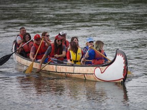 Minister of Crown-Indigenous Relations Carolyn Bennett (blue lifejacket) arrives at Batoche on a canoe with Metis youth from around Canada for a historic signing on Friday, July 20, 2018
