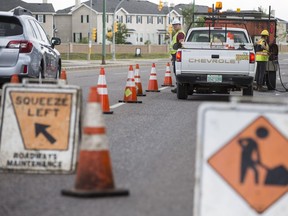 City of Saskatoon roadway workers patch cracks on Taylor Street East near Boychuck Drive in Saskatoon, SK on Thursday, July 26, 2018. On Sunday, July 15th, the crew where narrowly missed by a truck but some specialized patching equipment was damaged.