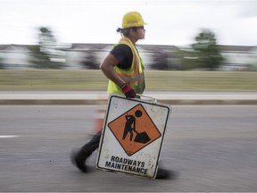 City of Saskatoon roadway workers patch cracks on Taylor Street East near Boychuck Drive in Saskatoon, SK on Thursday, July 26, 2018. On Sunday, July 15th, the crew where narrowly missed by a truck but some specialized patching equipment was damaged.