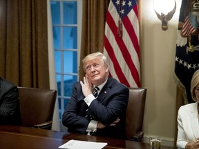 President Donald Trump, center, accompanied by House Ways and Means Committee chairman Rep. Kevin Brady, R-Texas, left, and Rep. Diane Black, R-Tn., right, gestures as he listens to a question from a reporter as the media is escorted out of the Cabinet room of the White House, Tuesday, July 17, 2018, in Washington. Trump says he meant the opposite when he said in Helsinki that he doesn't see why Russia would have interfered in the 2016 U.S. elections.