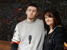 Marie Agioritis and her son Kayle Best stand in front of a blackboard covered in messages to her other son, Kelly Best, who died of a fentanyl overdose. (Photo: Heidi Atter)