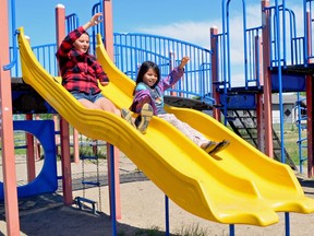 Paralympian Brittany Hudak (left) and Elizabeth Roberts play in a playground in La Ronge in May 2018. Hudak is a two-time Paralympian who was born missing part of her left arm and Elizabeth was born missing part of her right arm. Elizabeth says she hopes to one day travel the world as a competitive paraskier as Hudak has done.