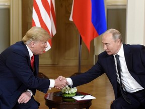 U.S. President Donald Trump, left and Russian President Vladimir Putin shake hands during their meeting in the Presidential Palace in Helsinki, Monday, July 16, 2018.