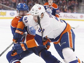 New York Islanders' John Tavares (91) and Edmonton Oilers' Adam Larsson (6) battle for the puck during first period NHL action in Edmonton, Alta., on Tuesday, March 7, 2017.