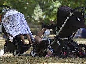 Mother and children shelter from the sun at St James's Park in London, as the hot weather continues across the country, Monday July 23, 2018. A public health warning has been issued for parts of England this week parts of the country braces itself for the predicted hottest day of the year.
