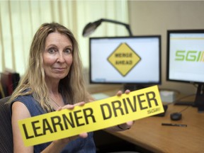 Shay Shpak, director of driver development and safety practices at SGI, holds up a Learner Driver sticker in her office in Regina.