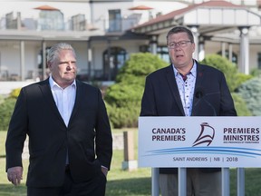 Ontario Premier Doug Ford, left, and Saskatchewan Premier Scott Moe talk with reporters as the Canadian premiers meet in St. Andrews, N.B., on Thursday, July 19, 2018. Ford and Moe have agreed to fight the federal government plan to impose a carbon tax.