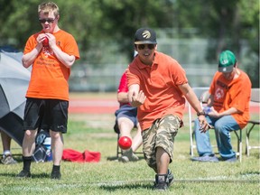 Jason Urbano, right, an athlete in the Special Olympics Global Day of Inclusion, makes a toss in a game of bocce ball being held at the Canada Games Athletic Complex in Douglas Park on July 21, 2018.