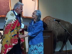 Elder Melvina Eagle (right) presents Thundering Ahead co-chair and Nutrien chief financial officer Wayne Brownlee with a traditional blanket during the presentation announcing Nutrien's $3 million donation to the Wanuskewin Heritage Park Thundering Ahead campaign in Saskatoon on July 18, 2018. (Erin Petrow/ Saskatoon StarPhoenix)