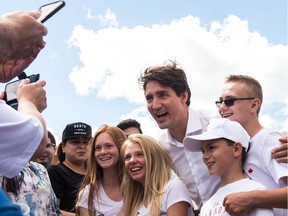 Prime Minister Justin Trudeau has his photo taken with people at the Evraz steel plant on Canada Day.