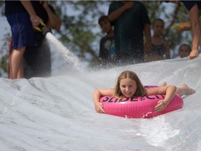 Alexis Kreese slides down the giant slip-and-slide set up by the Saskatoon Fire Department in Optimist Park on August 2, 2018.