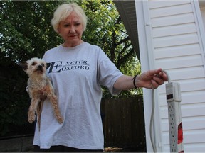 Standing with her nine-year-old Yorkshire Terrier, Basil Shelley LePoudre holds up a piece of garbage left behind by a stranger, outside of her home on Aug. 3, 2018. She said she felt "violated" when a random man dropped off several large pieces of furniture outside of her Exhibition neighbourhood home on Aug. 1. While the City of Saskatoon has since removed the junk, she said the illegal dump caused her stress and at least on sleepless night.