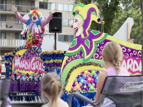 A Clown on the Mardi Gras float waves to attendees during the Saskatoon Ex Parade in Saskatoon, Sask. on August 7, 2018.