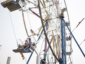 (L to R) Colby Goodwin and Jason Goodwin ride the Ferris wheel during the Saskatoon Exhibition at Prairieland Park in Saskatoon on Aug. 8, 2018.