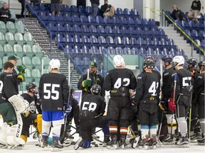 Humboldt Broncos players gather around head coach Nathan Oystrick during the SJHL team's training camp.