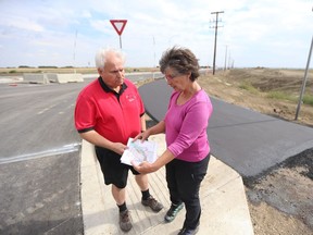 Richard Huziak and Candace Savage with the Northeast Swale Watchers look at maps while standing at the intersection of the new extension of McOrmond Drive and Lowe Road just east of the Northeast Swale on August 30, 2018.