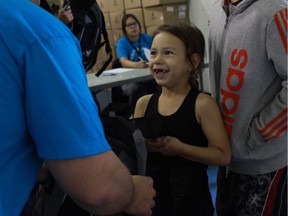 Five-year-old Arabelle Bird receives a backpack to fill with school supplies at the 4th annual carnival and backpack giveaway at White Buffalo Youth Lodge in Saskatoon.