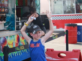 Lucas Lynds stands under the mist in front of the Slush Zone, a truck selling slushies at the Saskatoon Ex, in Saskatoon, Sask., on Friday, August 10, 2018. Temperatures on Friday reached 38° Celsius, and everyone attending or working at the exhibition are trying to find ways to stay cool.