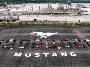 In this photo provided by the Ford Motor Co., Mustang vehicles are parked to spell out "10,000,000" on a parking lot at the Flat Rock Assembly plant on Aug. 8, in Flat Rock, Mich. The commas were represented by the first Mustang produced and the 10 millionth, a 2019 Wimbledon White GT V8 six-speed manual convertible.