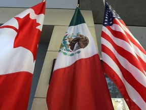 (FILES) This file photo taken on September 24, 2017 shows the Mexican, US and Canadian flags in the lobby where the third round of the NAFTA renegotiations took place in Ottawa, Ontario. Canada announced on January 23, 2018 it will sign on the Trans Pacific Partnership, moving to diversify its trade relationships as Canadian, US and Mexican negotiators kicked off a sixth round of talks on a 1994 free trade pact that Washington has threatened to dump. Canada had initially balked at joining the proposed TPP last year, acting as the main holdout in negotiations after US President Donald Trump decided in early 2017 to go it alone under his "America First" policy.