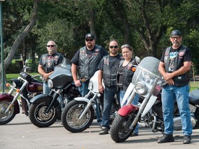 Bikers Against Child Abuse, from left, known by their "road names" Freedom, Hoss, Crocket, Pebbles and Kinger stand next to their bikes in Candy Cane Park.