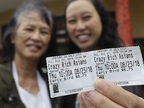 In this Thursday, Aug. 23, 2018 photo, Audrey Sue-Matsumoto, right, holds tickets as she poses for photos with her mother Alice Sue while interviewed outside of a movie theater after watching the movie Crazy Rich Asians in Daly City, Calif. It was Alice Sue's second time watching the movie. When "Crazy Rich Asians" surpassed expectations and grabbed the top spot in its opening weekend, the film also pulled off another surprising feat. It put Asians of a certain age in theater seats.