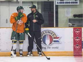 Humboldt Broncos bus crash survivor Derek Patter talks to head coach Nathan Oystrick during the first day of the Humboldt Broncos training camp at Elgar Petersen Arena in Humboldt, Sask., Friday, August 24, 2018.