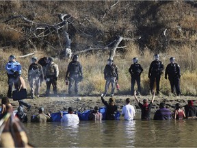 In this Nov. 2, 2016 file photo, protesters demonstrating against the expansion of the Dakota Access Pipeline wade in cold creek waters confronting local police as remnants of pepper spray waft over the crowd near Cannon Ball, N.D. North Dakota is demanding $38 million from the federal government to reimburse the state for costs associated with policing large-scale and prolonged protests against the oil pipeline. North Dakota Attorney General Wayne Stenehjem filed an administrative claim Friday, July 20, 2018.