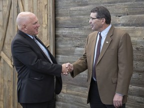 Saskatchewan Urban Municipality Association (SUMA) president Gordon Barnhart, left, and Saskatchewan Association of Rural Municipalities Association (SARM) president Ray Orb shake hands in Regina in April. Both SUMA and SARM are opposed to the possibility of moving municipal elections from October of 2020 to October of 2021.