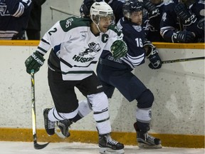 University of Saskatchewan Huskies defence Kendall McFaull and Mount Royal University Cougars forward Austin Adamson battle along the boards during the first period of CIS hockey action at Rutherford Rink in Saskatoon, SK on Saturday, February 10, 2018.