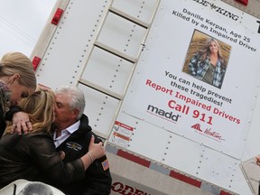 Allan and Melanie Kerpan embrace in May 2017 after unveiling the new Call 911 truck decal of their daughter Danille Kerpan, who was killed by a drunk driver in Saskatoon.
