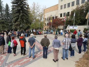 Attendees at a climate change rally in Saskatoon on Sept. 8, 2018 join hands in solidarity for a prayer.