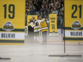 Humboldt Broncos forward Derek Patter, left, hugs Scott Thomas, father of former Humboldt Broncos team member Evan Thomas during the Humboldt Broncos post game ceremony after they took on the Nipawin Hawks in the Broncos home opener in Humboldt, SK on Wednesday, September 12, 2018.