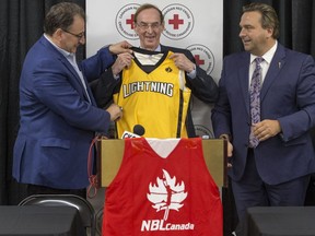 London Lightning owner Vito Frijia, left, presents a jersey to Merlis Belsher as MLA Ken Cheveldayoff watches on during a media event Monday announcing a National Basketball League of Canada game at Merlis Belsher Place in Saskatoon on Nov. 2 between the league finalists, London Lightning and the Halifax Hurricanes.