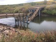 A collapsed bridge is seen in the Regional Municipality of Clayton in a Tuesday, Sept. 18, 2018, handout photo. A rural politician in eastern Saskatchewan says that no geotech investigation was performed on a riverbed that resulted in a newly built bridge collapsing hours after opening.