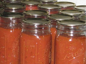 This undated photo shows canned tomatoes in jars in New Paltz, N.Y. A pot of tomatoes, cooked down, blended, and then canned, brings some summer-y flavor to the dead of winter. (Lee Reich via AP) ORG XMIT: NYLS308