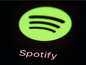 This March 20, 2018, file photo shows the Spotify app on an iPad in Baltimore. A former sales executive is suing Spotify for gender discrimination and equal pay violations, saying executives organized "boys' trips" that excluded women and that it paid men more for the same work.