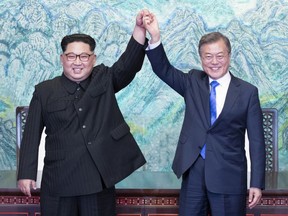 FILE- in this April 27, 2018, file photo, North Korean leader Kim Jong Un, left, and South Korean President Moon Jae-in raise their hands after signing on a joint statement at the border village of Panmunjom in the Demilitarized Zone, South Korea. As North Korea prepares for a massive parade Sunday, Sept. 9, 2018, to celebrate the 70th anniversary of its founding, worry is rising in South Korea that a tentative detente is slipping away. Senior Chinese official Li Zhanshu will also attend the parade, which would underscore China's role as an important player in efforts to solve the nuclear crisis. (Korea Summit Press Pool via AP, File)