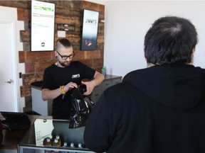 BESTPHOTO -- Jimmy's Cannabis employee Devin Poth prepares products for a customer on Oct. 17, 2018, the day the store opened in Martensville and the day cannabis was legalized in Canada.
