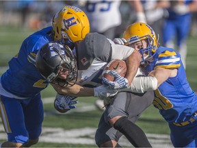 Winnipeg Rifles wide receiver Brendan Naujoks gets tackled by Hilltops defensive back Logan Bitz (L) and Hilltops linebacker Adam Benkic (R) during the game at SMF Field in Saskatoon on Sunday, October 21, 2018.