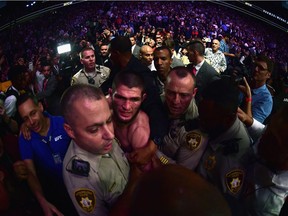 LAS VEGAS, NV - OCTOBER 06:  Khabib Nurmagomedov of Russia is escorted out of the arena after defeating Conor McGregor of Ireland in their UFC lightweight championship bout during the UFC 229 event inside T-Mobile Arena on October 6, 2018 in Las Vegas, Nevada.