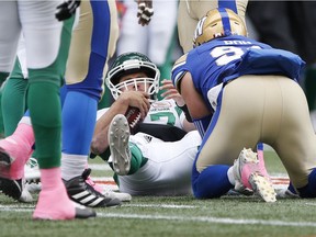 Saskatchewan Roughriders quarterback Zach Collaros (17) gets up after getting sacked by Craig Roh (93) during the first half of CFL action in Winnipeg on Saturday.