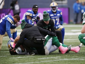 Saskatchewan Roughriders' Dariusz Bladek (66) is attended to after suffering an injury during the first half of CFL action against the Winnipeg Blue Bombers in Winnipeg Saturday, October 13, 2018.