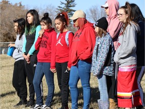 Friends and relatives hold hands on Grassick Playground during a vigil on Oct. 21, near the site where a 16-year-old girl was killed in Regina's North Central area.