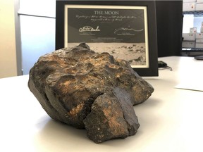 In this undated file photo, a 12-pound (5.5 kilogram) lunar meteorite discovered in Northwest Africa in 2017 rests on a table, in Amherst, N.H.  The lunar meteorite has been sold at auction for more than $600,000. Boston-based RR Auction announced Friday, Oct. 19, 2018,  the $612,500 winning bid for the meteorite, composed of six fragments that fit together like a puzzle, came from a representative working with the Tam Chuc Pagoda complex in Ha Nam Province, Vietnam.