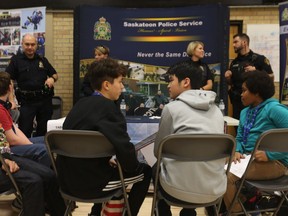 Keisuke Johnston (left) and Michael Chai (right) learn about the Saskatoon Police Service at a career fair event hosted at Mount Royal Collegiate on Nov. 14, 2018.