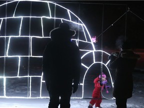 Chris Richards and Carla Fehr keep an eye on two-year-old Annalise Richards as she checks out the igloo during the Blue Cross Light Walk at the Enchanted Forest on Nov.16, 2018.